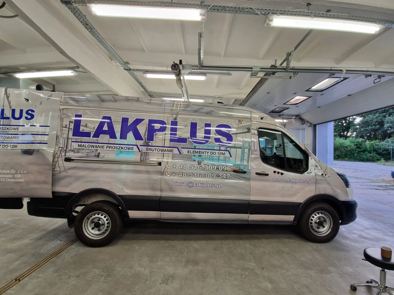 Oznakowanie reklamowe busa LAKPLUS Bok srebrnego busa LAKPLUS po wykonaniu oklejenia reklamowego