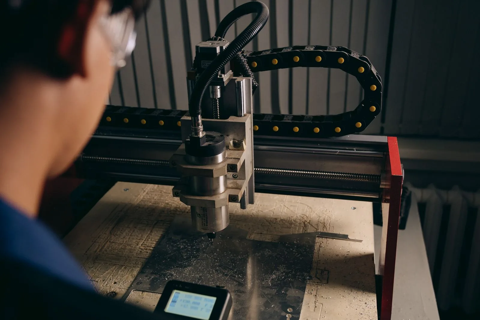 Precyzyjna obróbka materiału Operator przy neutralnej maszynie CNC podczas obróbki materiału